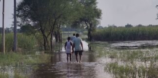 UP: बाराबंकी में बाढ़ का कहर, सड़क बनी नदी, कमर तक पानी में गुजरने को मजबूर ग्रामीण